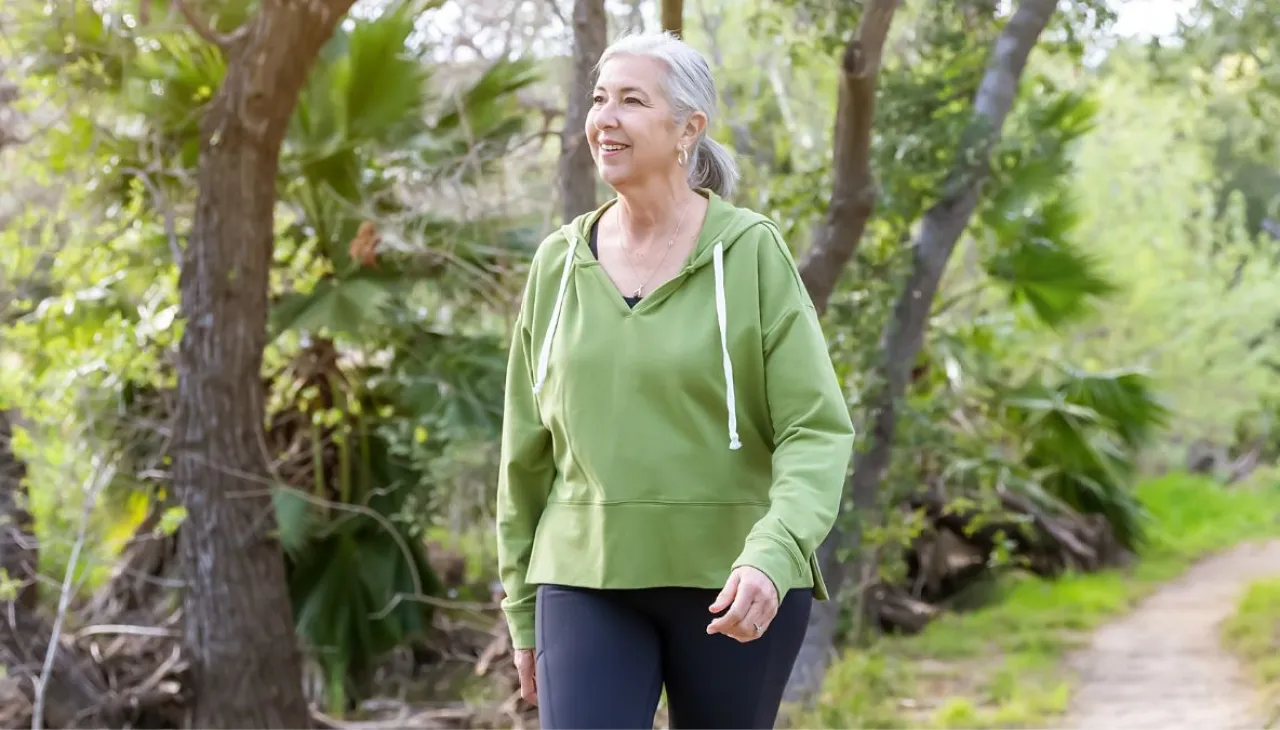 Woman over 40 walking outdoors to support hormone balance and belly fat healt
